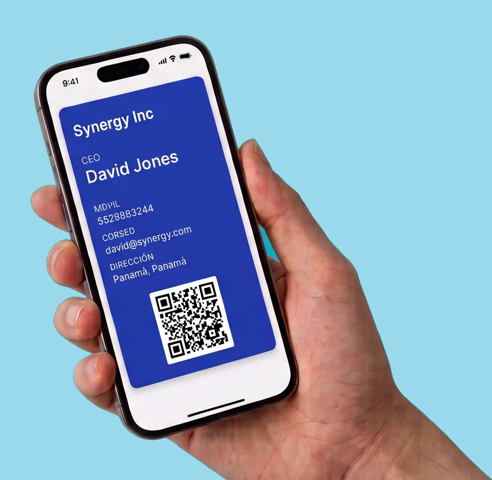 Mano sosteniendo un teléfono con una tarjeta de presentación digital guardada en la billetera, con nombre, cargo, datos de contacto y código QR.